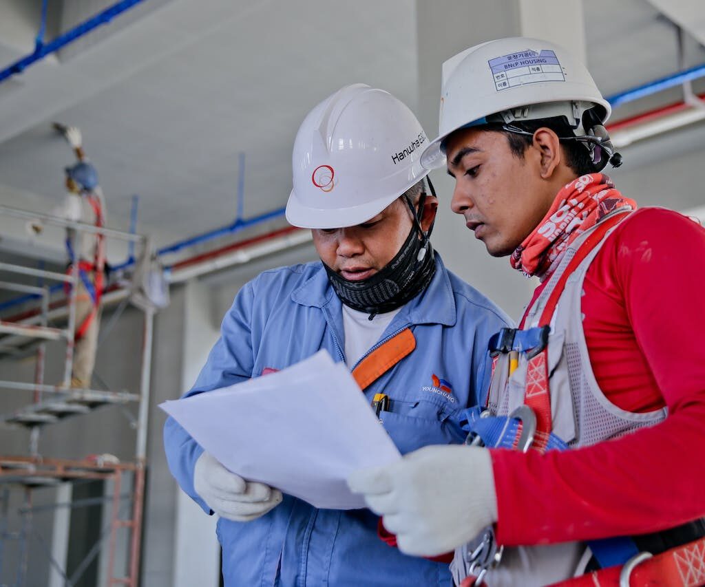 Construction workers reviewing plans at site