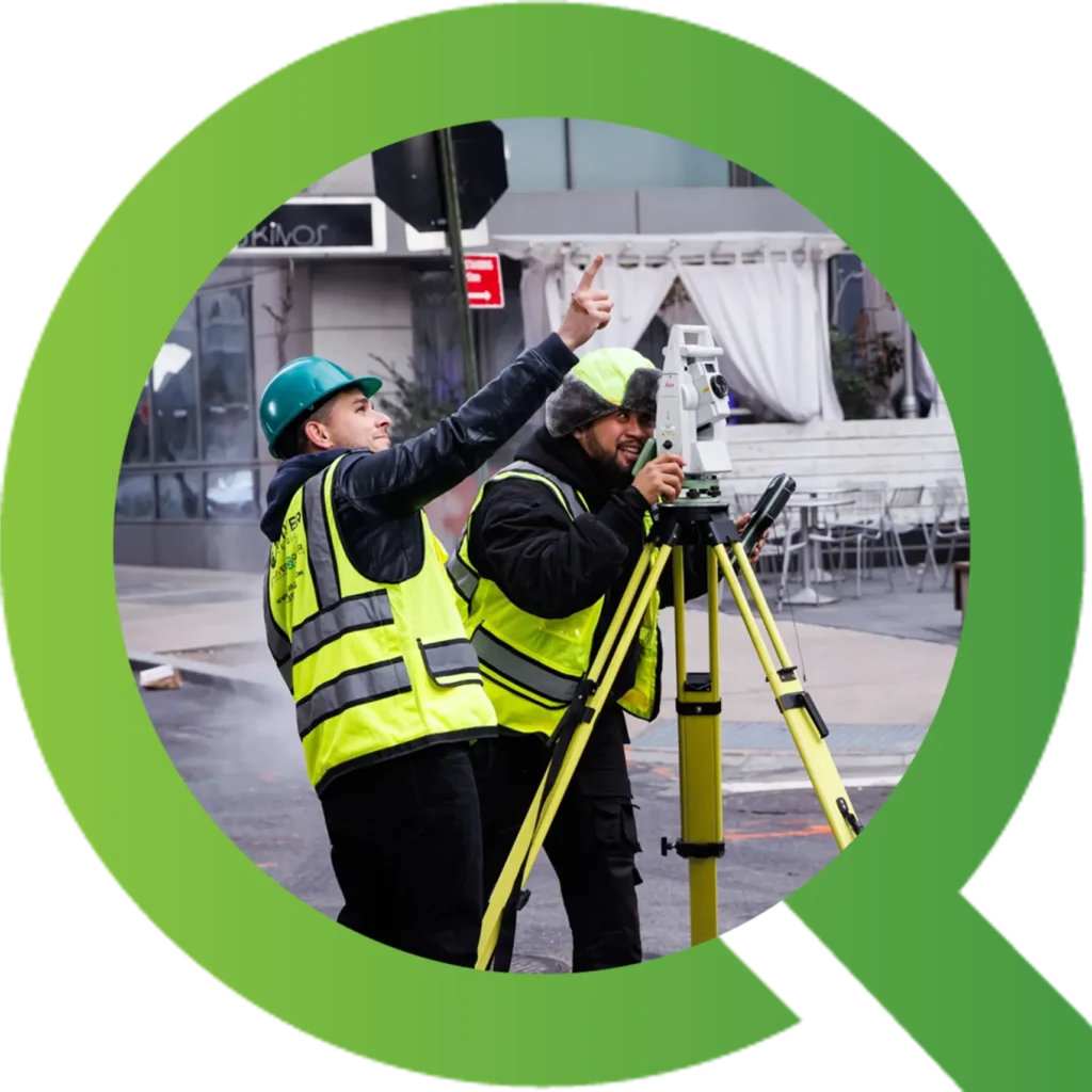 Surveyors working with theodolite on urban street.